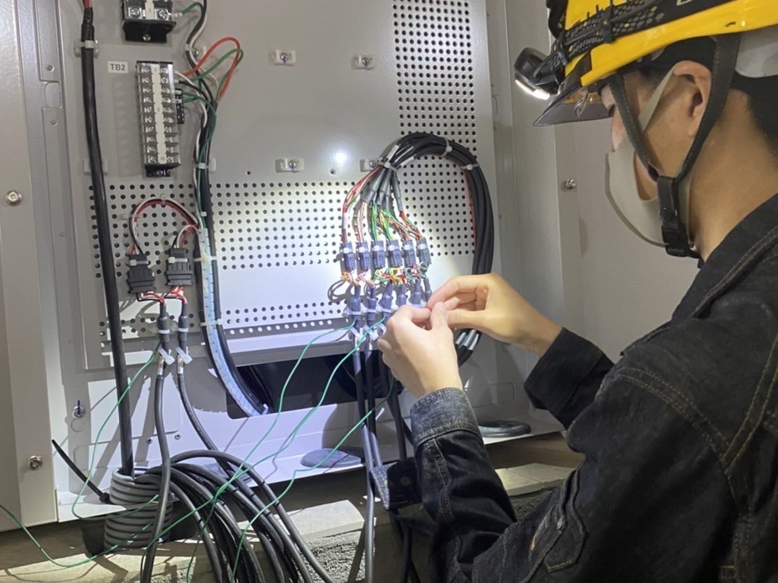 電気設備の盤内配線を行うスタッフ