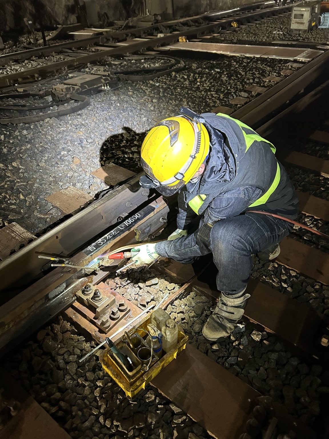 夜間に線路上で作業するスタッフ