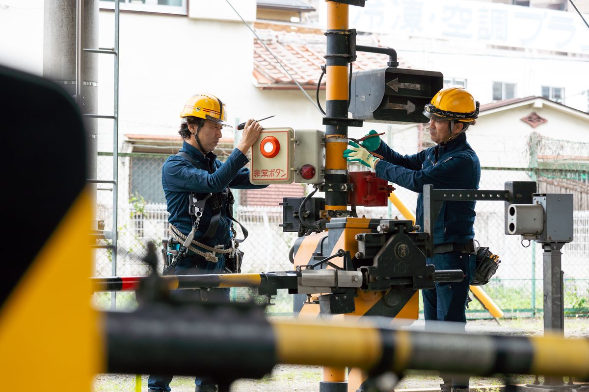 踏切の信号設備を施工するスタッフ