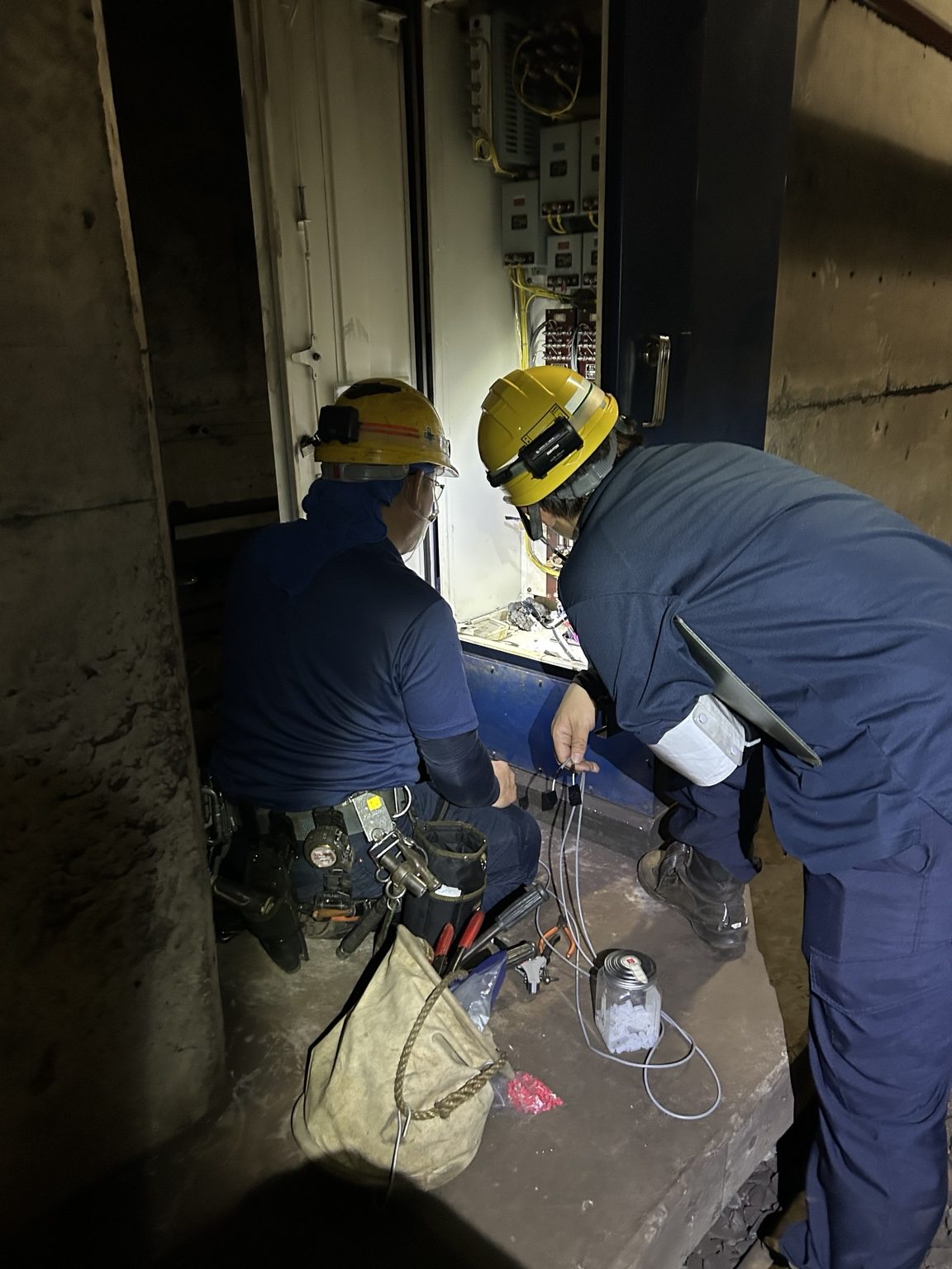 設備の内部を確認しながら作業する2人のスタッフ