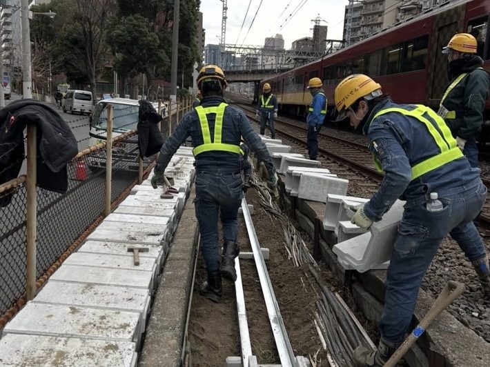 線路脇でトラフを設置するスタッフ